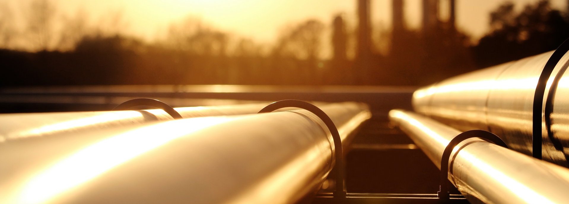 Beschreibung: Goldenes Stahlrohrnetz in der Rohölraffinerie bei goldenem Sonnenlicht