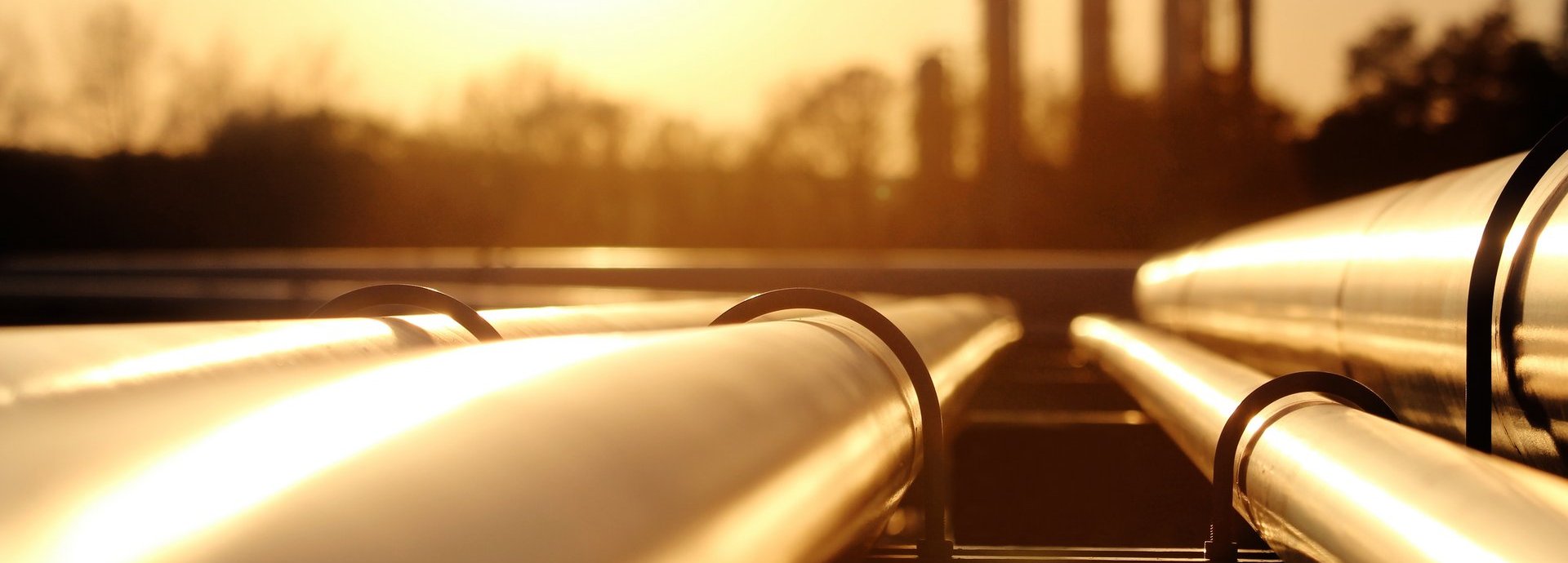 Beschreibung: Goldenes Stahlrohrnetz in der Rohölraffinerie bei goldenem Sonnenlicht