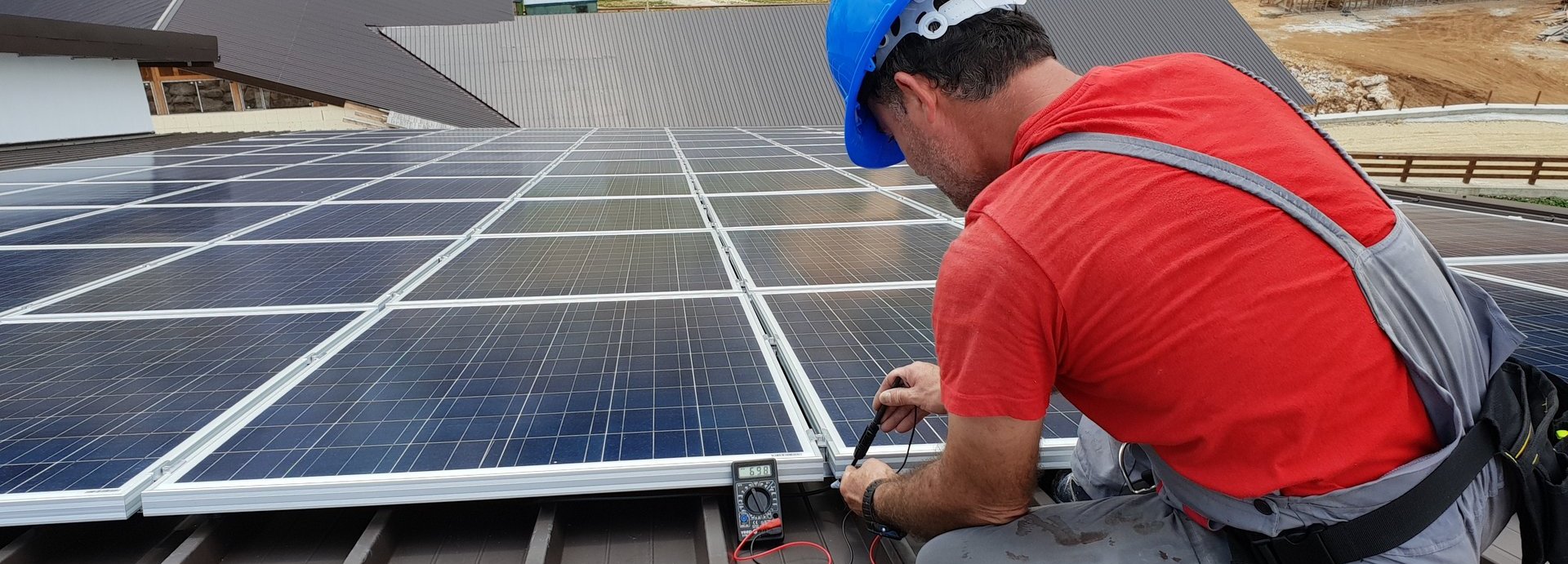 Beschreibung: Mechaniker-Fachkraft misst auf einem Dach die Solaranlage