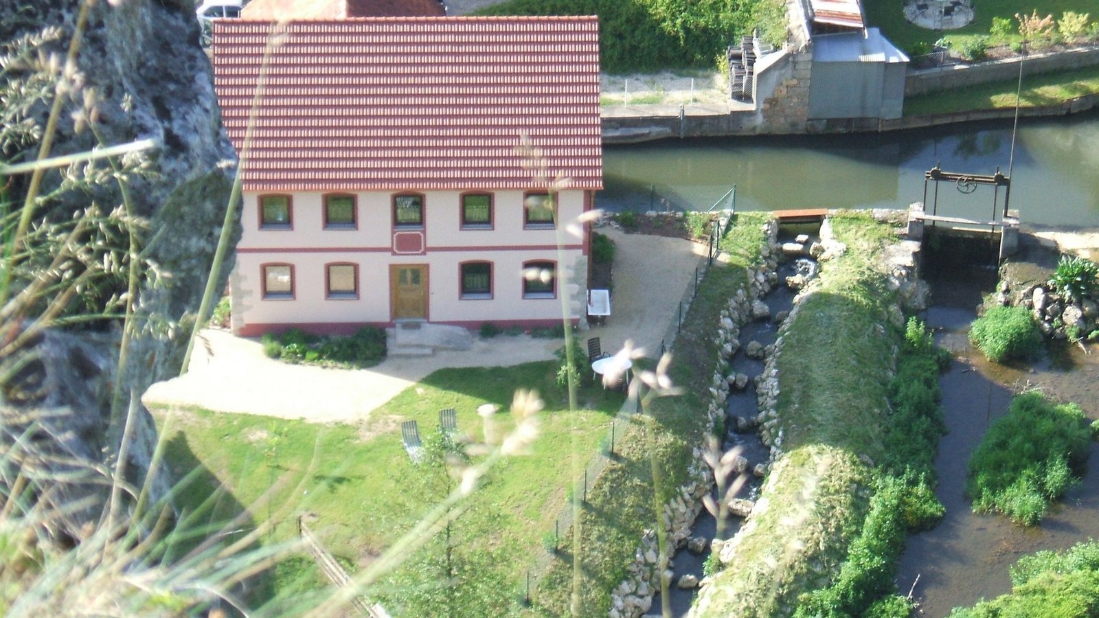 Wasserkraftanlage neben Haus mit Garten