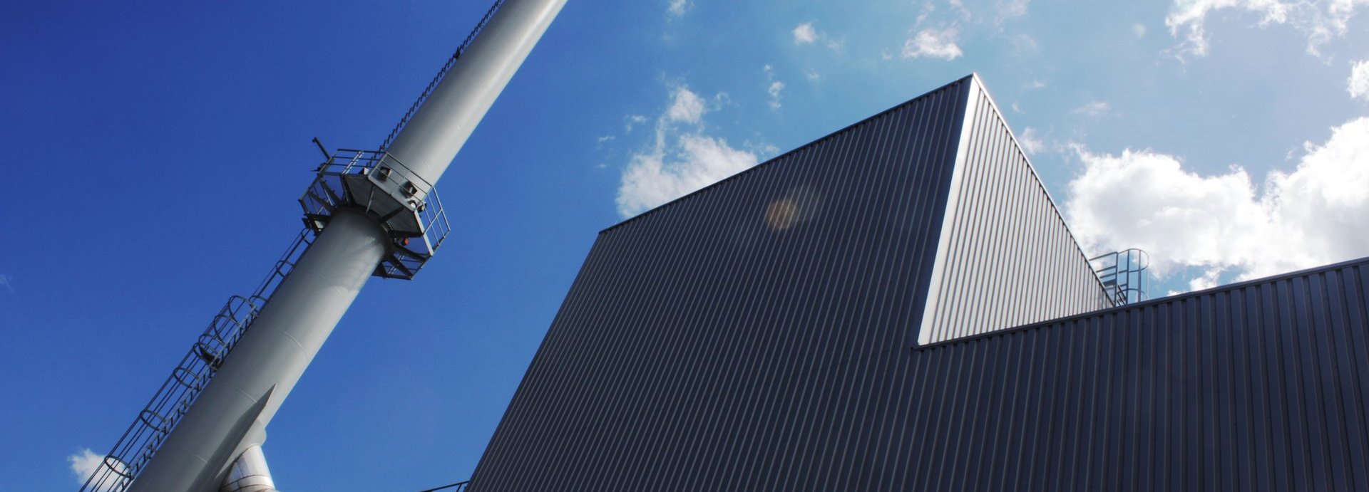 Beschreibung: Außenansicht eines Biomasseheizkraftwerks mit Schornstein