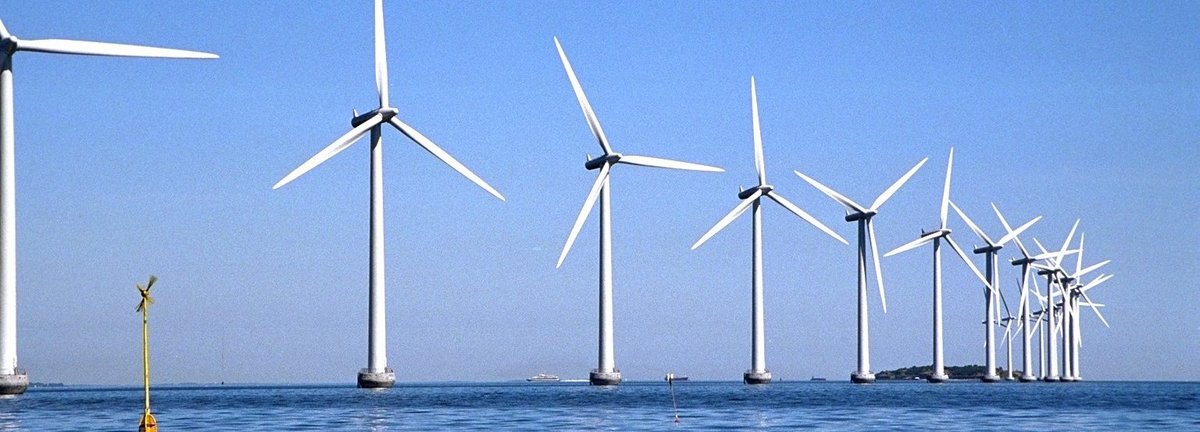 Windräder auf offener See offshore mit blauem Himmel