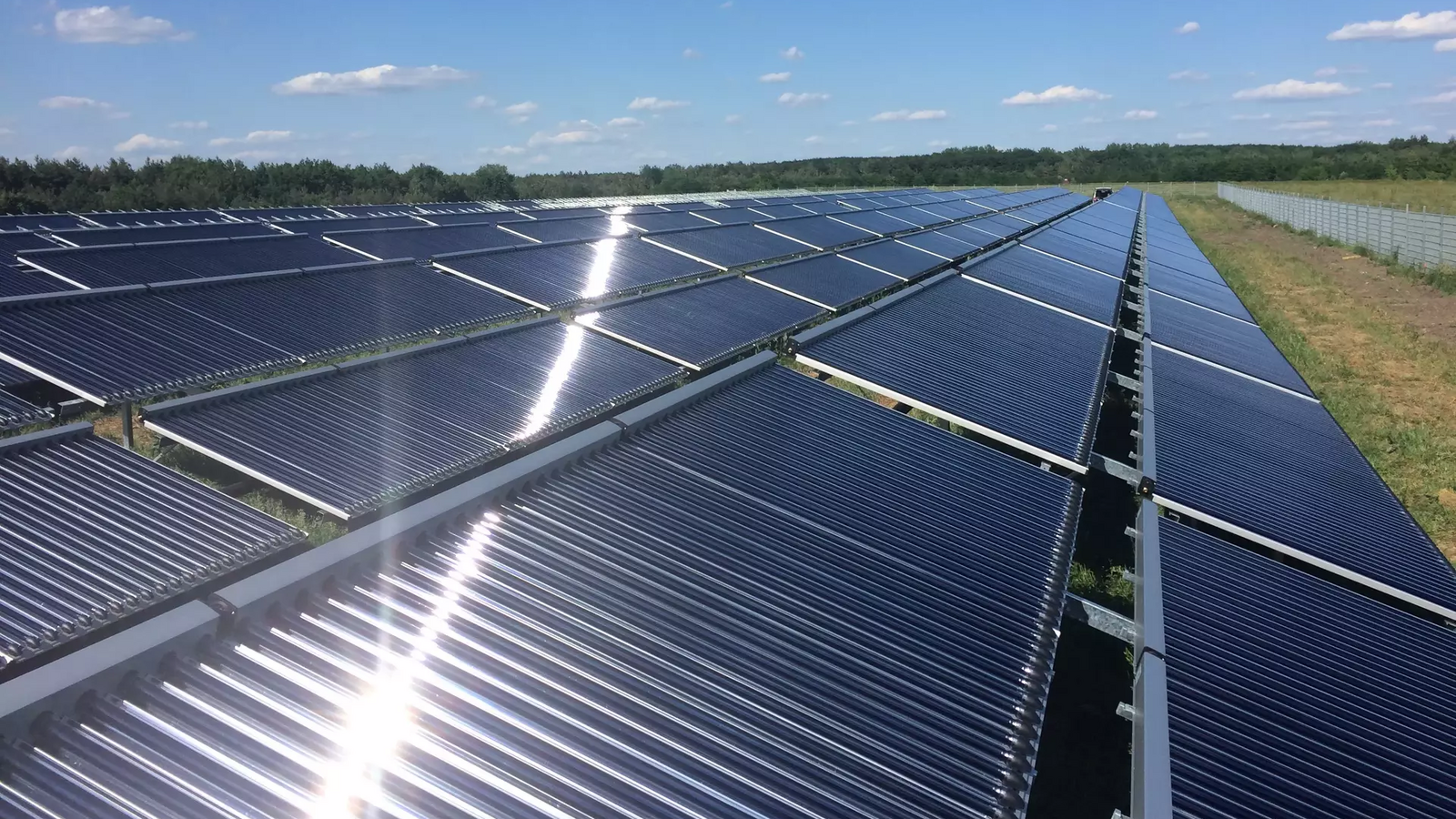 Beleuchtete Solarzellen auf einem Feld mit blauem Himmel