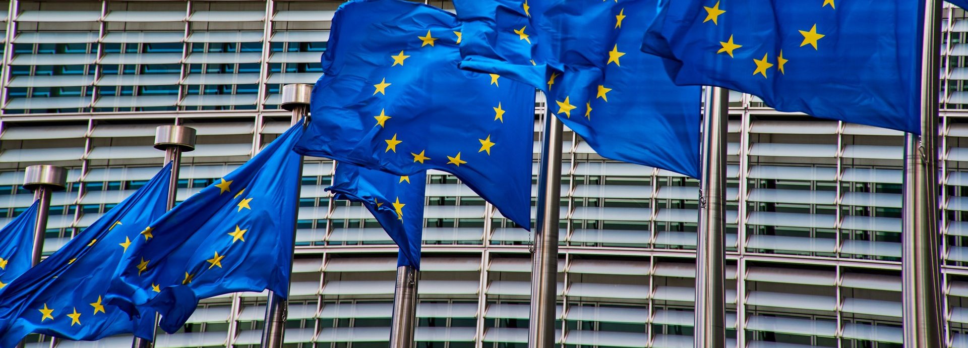 Gebäude der Europäischen Kommission. Im Vordergrund wehende EU Flaggen