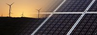 Solarkollektoren eingeblendet im Vordergrund mit Windrädern vor einem Sonnenuntergang am Horizont