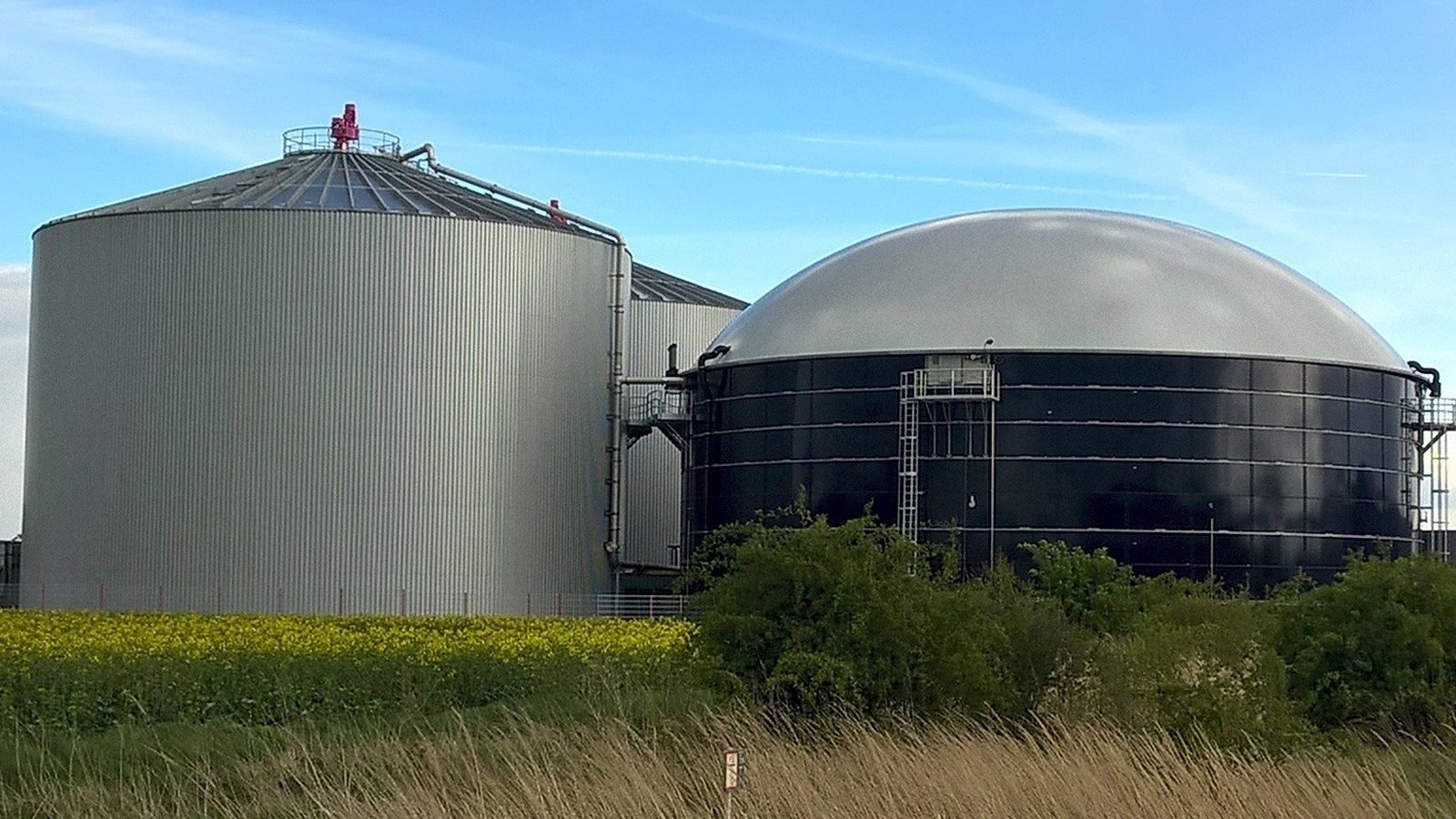 Biogasanlage auf Feld vor hellem blauem Himmel