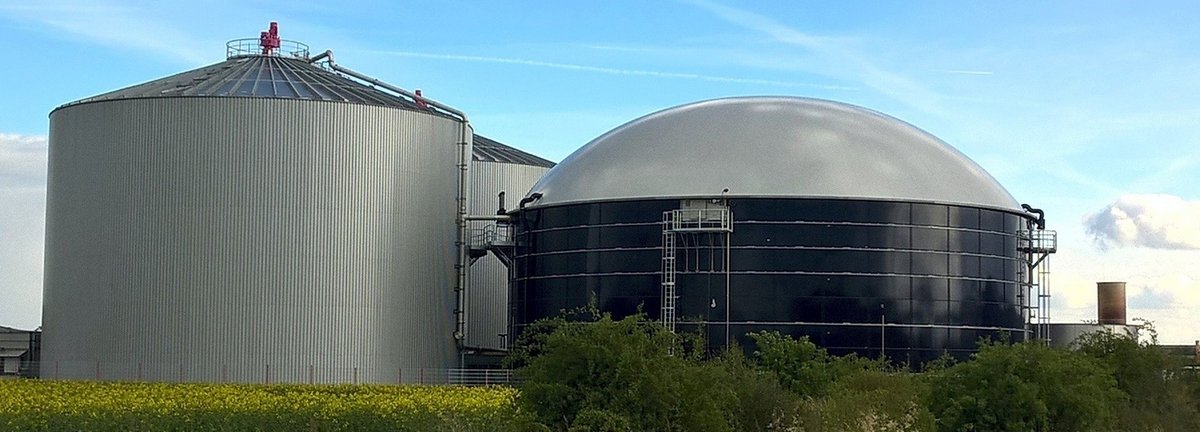 Biogasanlage auf Feld vor hellem blauem Himmel