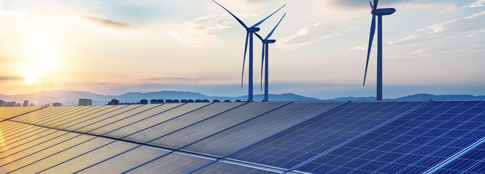 Beschreibung: Solarkollektoren mit Windrädern im Hintergrund vor blauem, wolkenbehangenem Himmel