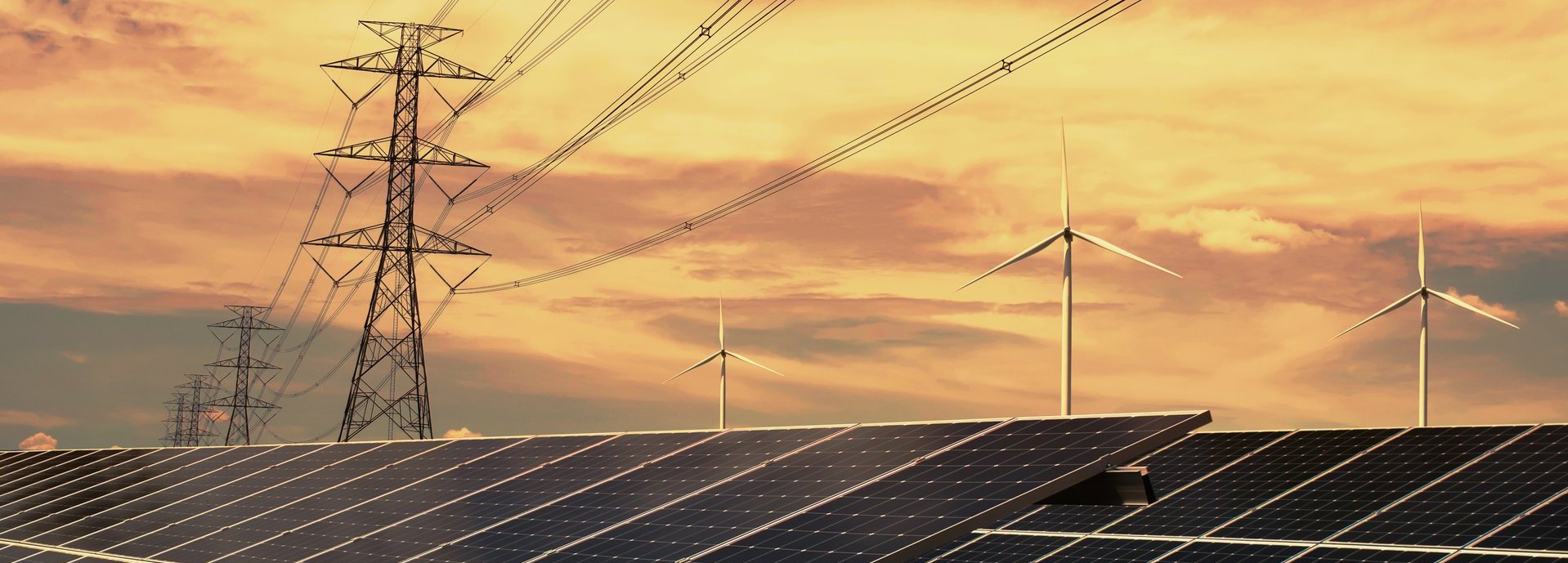 Strommasten Solarkolelktoren und Windräder vor orangenem Himmel mit Sonnenuntergang