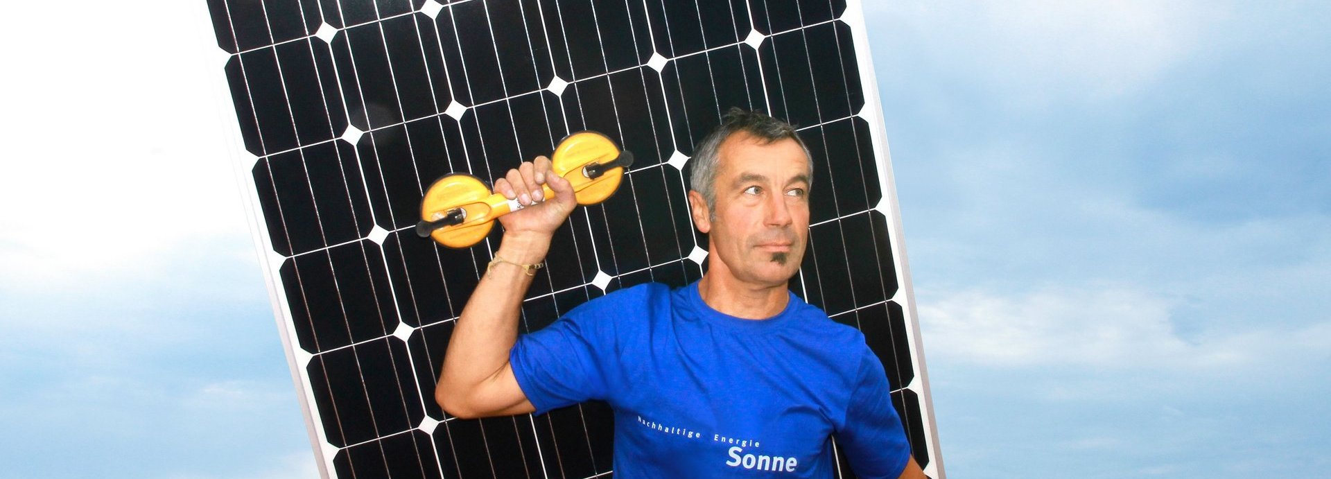Mann mit blauem Shirt transportiert eine Solarzelle