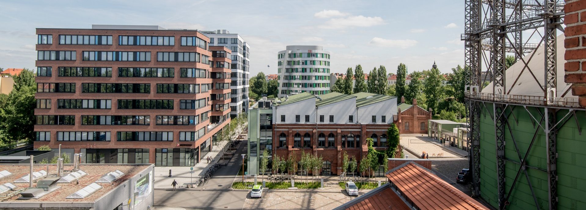 Erhöhte Ansicht auf den EUREF Campus mit vereinzelten Menschen und geparkten Autos
