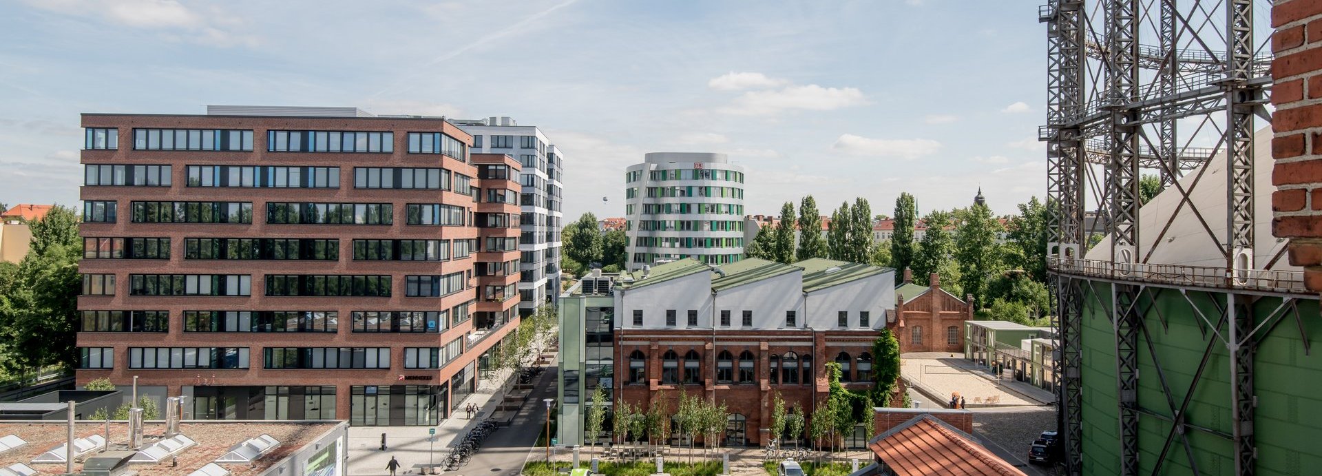 Erhöhte Ansicht auf den EUREF Campus mit vereinzelten Menschen und geparkten Autos