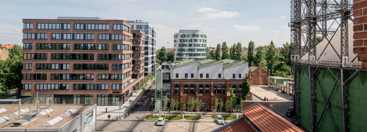 Erhöhte Ansicht auf den EUREF Campus mit vereinzelten Menschen und geparkten Autos