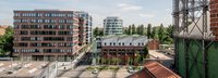 Erhöhte Ansicht auf den EUREF Campus mit vereinzelten Menschen und geparkten Autos