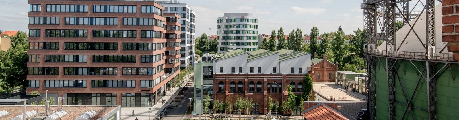 Erhöhte Ansicht auf den EUREF Campus mit vereinzelten Menschen und geparkten Autos
