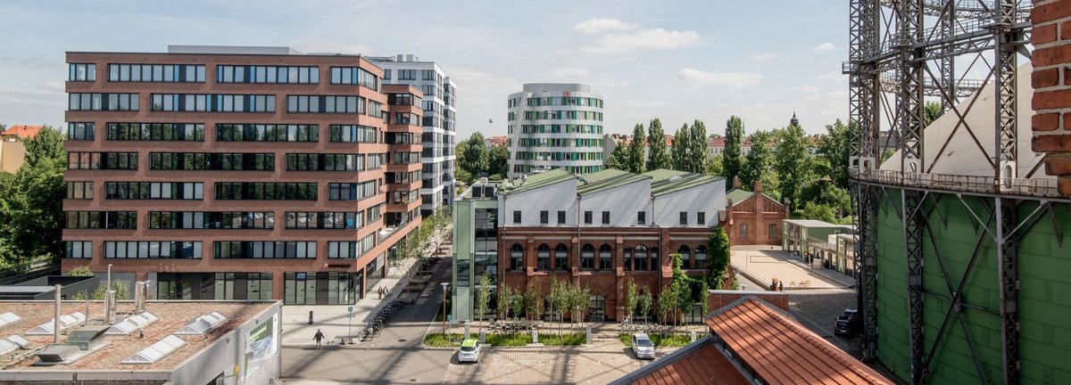 Erhöhte Ansicht auf den EUREF Campus mit vereinzelten Menschen und geparkten Autos