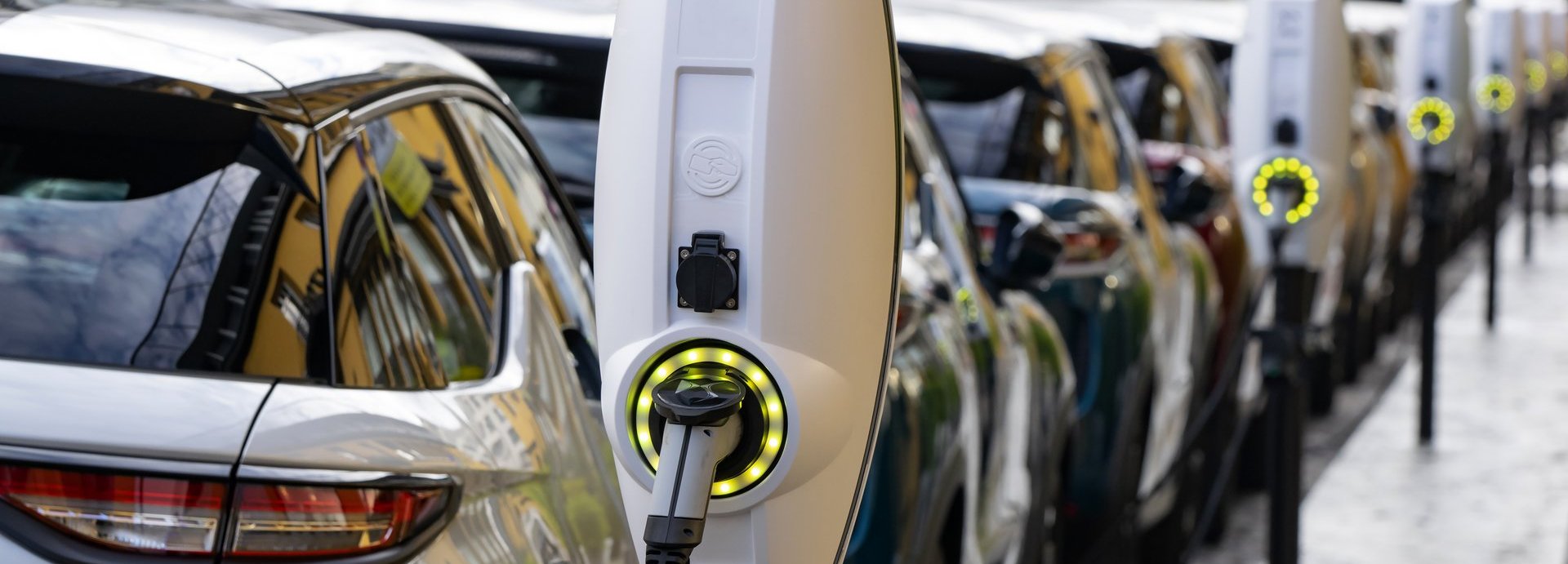 Reihe von Elektroladesäulen, an denen Autos geladen werden in der Stadt