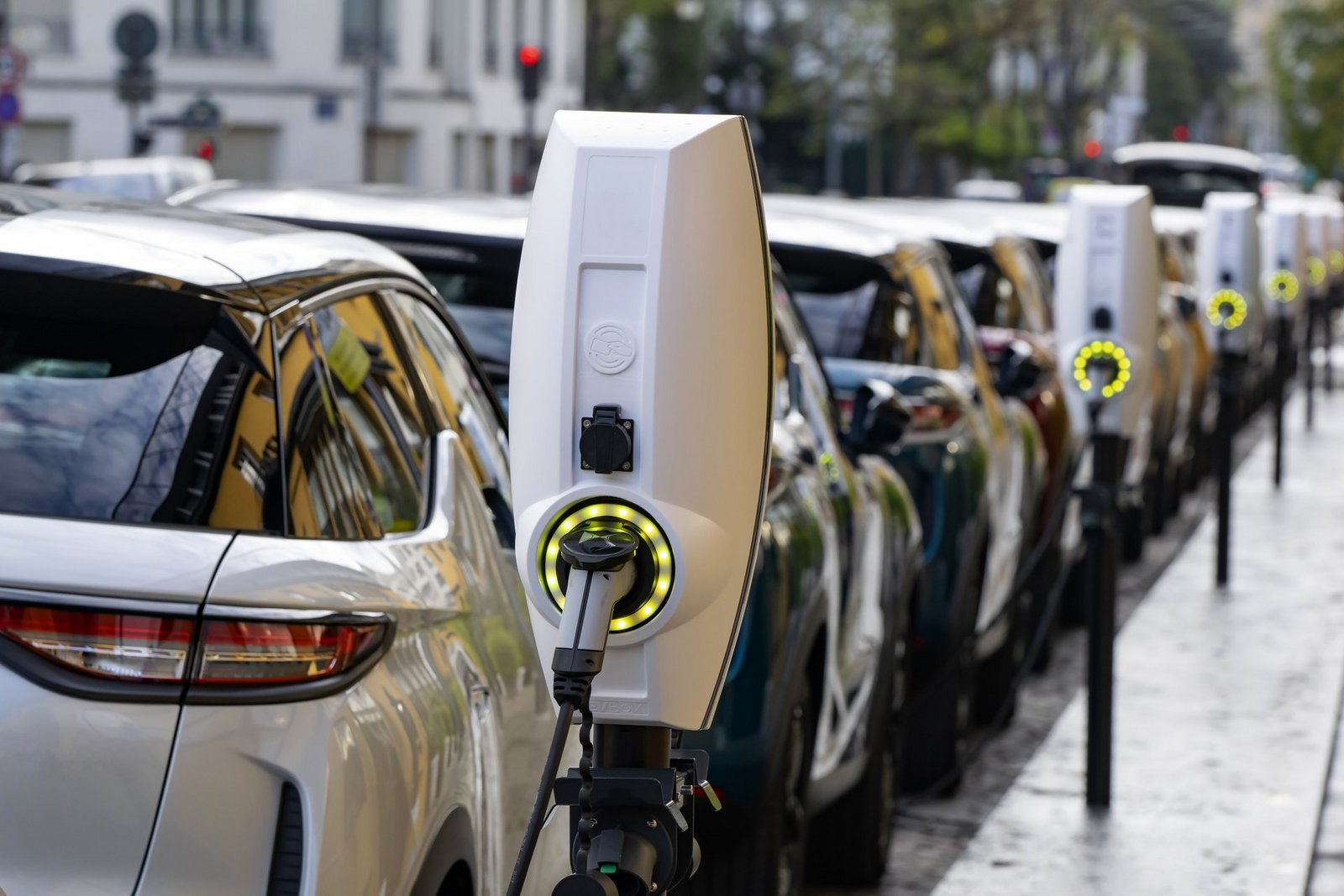 Reihe von Elektroladesäulen an denen Autos geladen werden in der Stadt