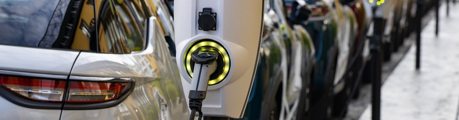 Reihe von Elektroladesäulen an denen Autos geladen werden in der Stadt