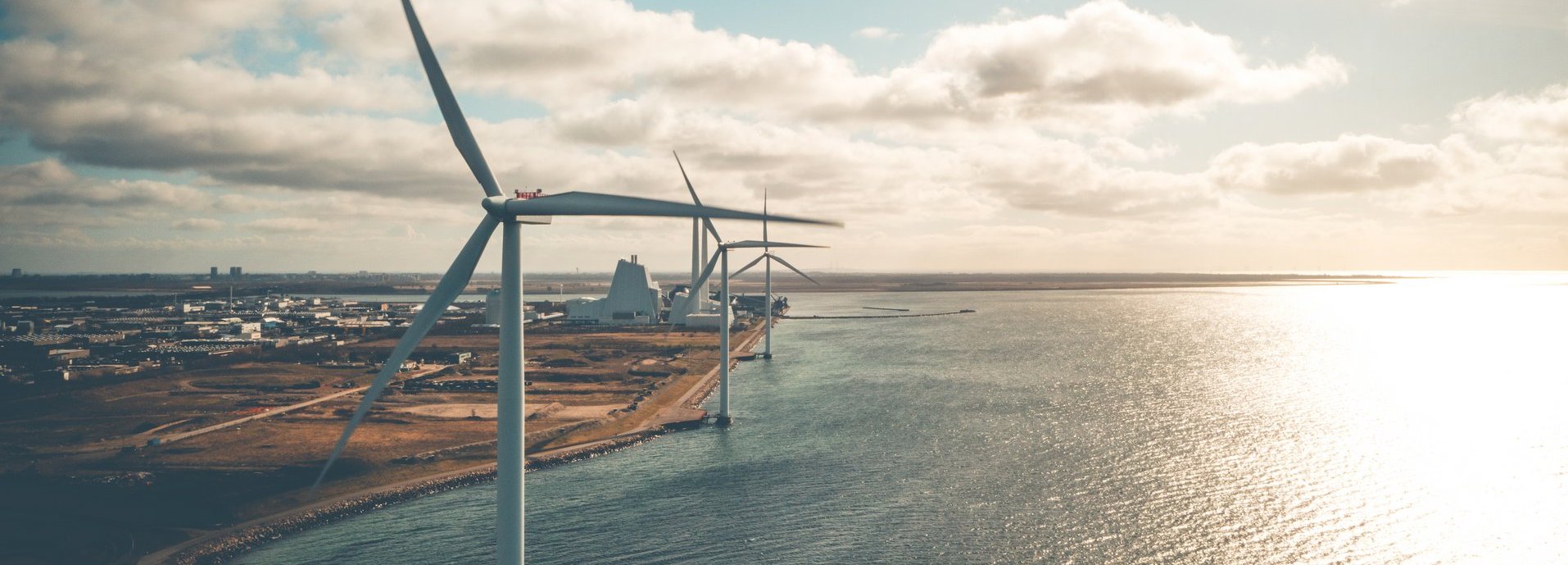 Windräder an der Küste mit wolkigem Himmel