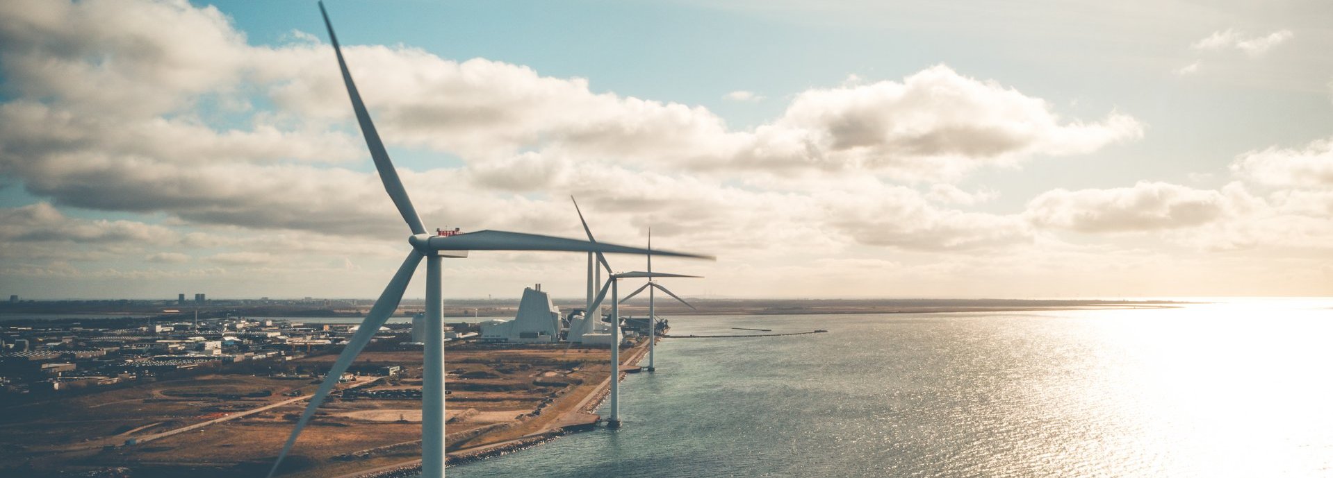 Windräder an der Küste mit wolkigem Himmel