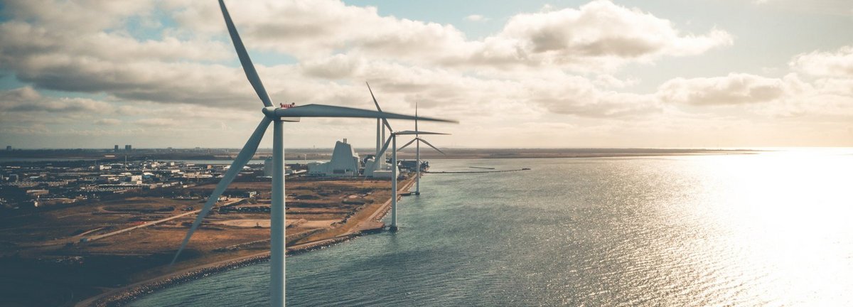 Windräder an der Küste mit wolkigem Himmel