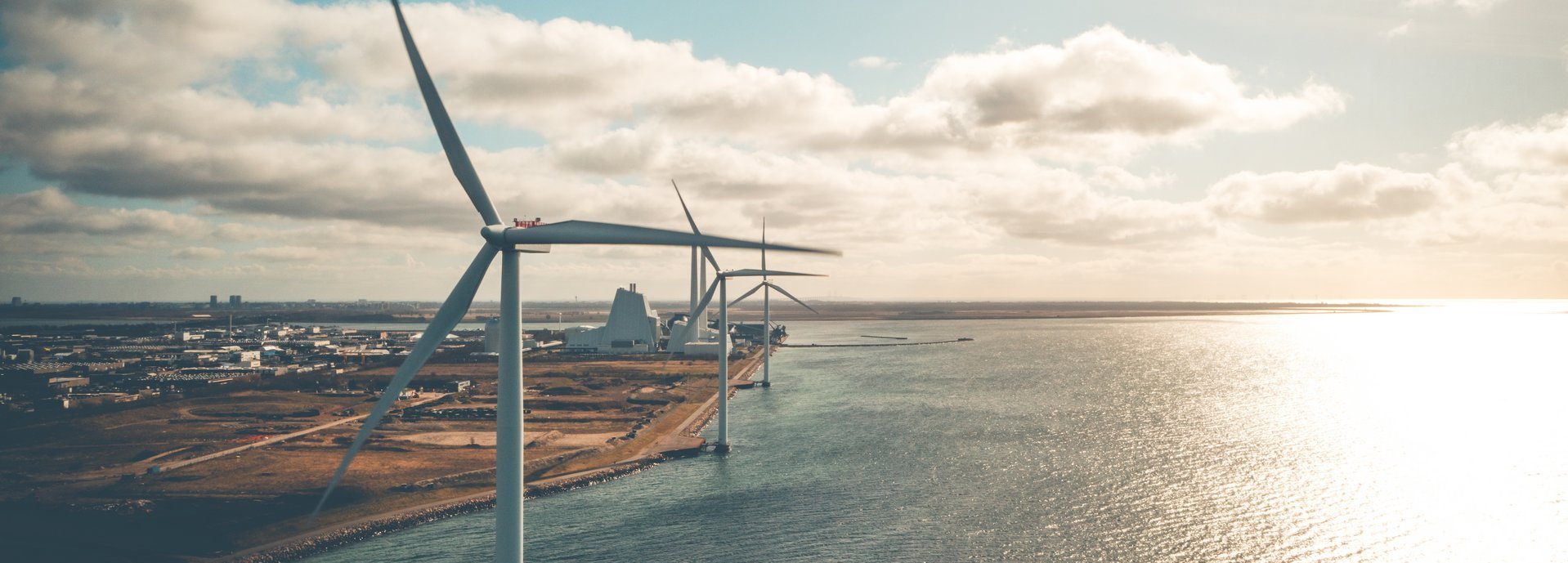 Windräder an der Küste mit wolkigem Himmel