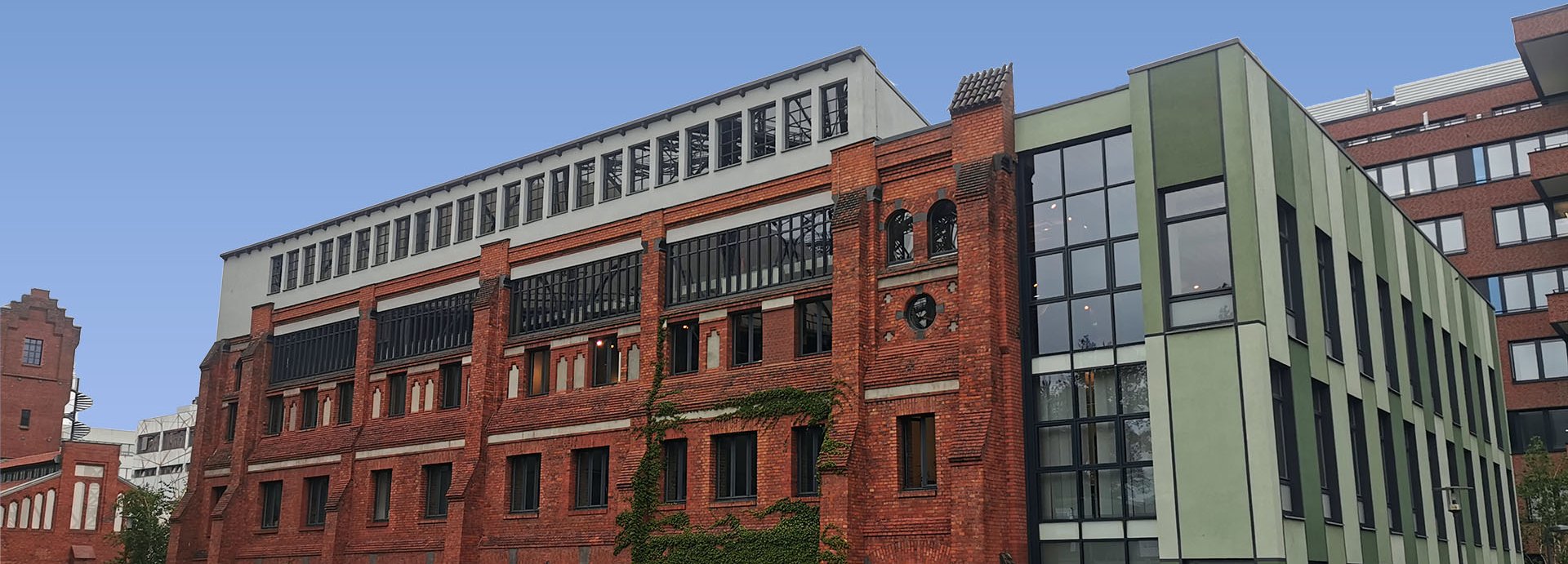 Haus 16 auf dem EUREF-Campus, Ziegelsteingebäude mit Volleyballfeld im Vordergrund