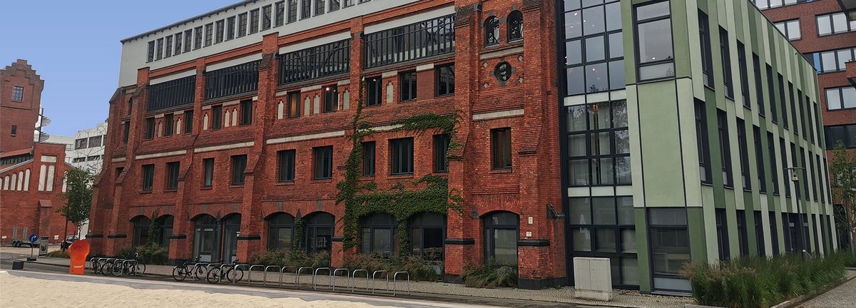 Haus 16 auf dem EUREF-Campus, Ziegelsteingebäude mit Volleyballfeld im Vordergrund