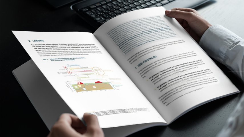 Bildbeschreibung: Heft mit Diagramm und Text, das in der Hand gehalten wird