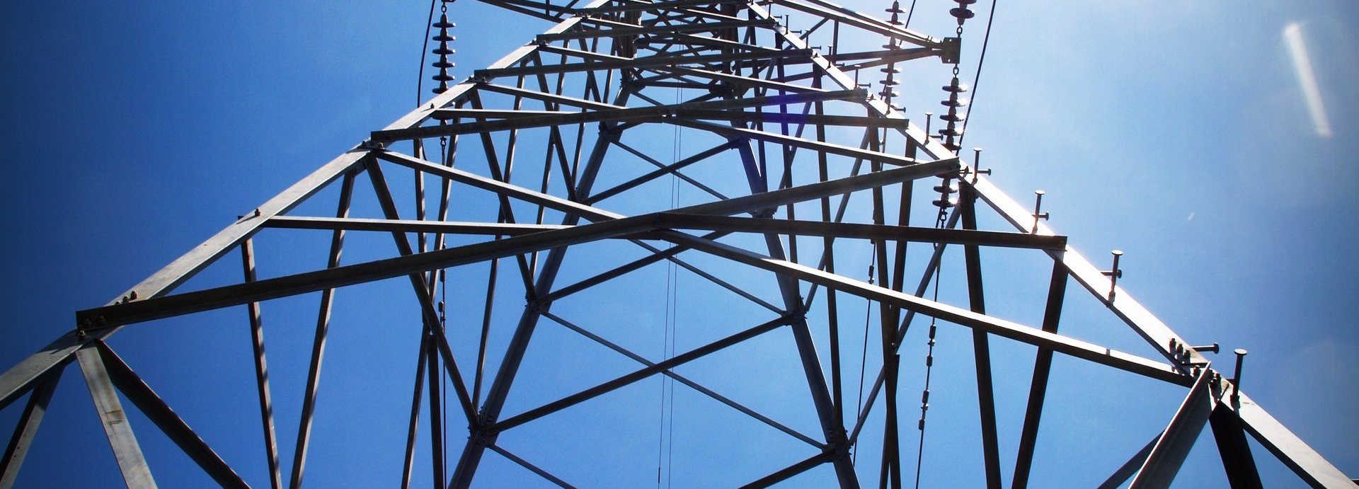 Strommast von unten vor blauem Himmel