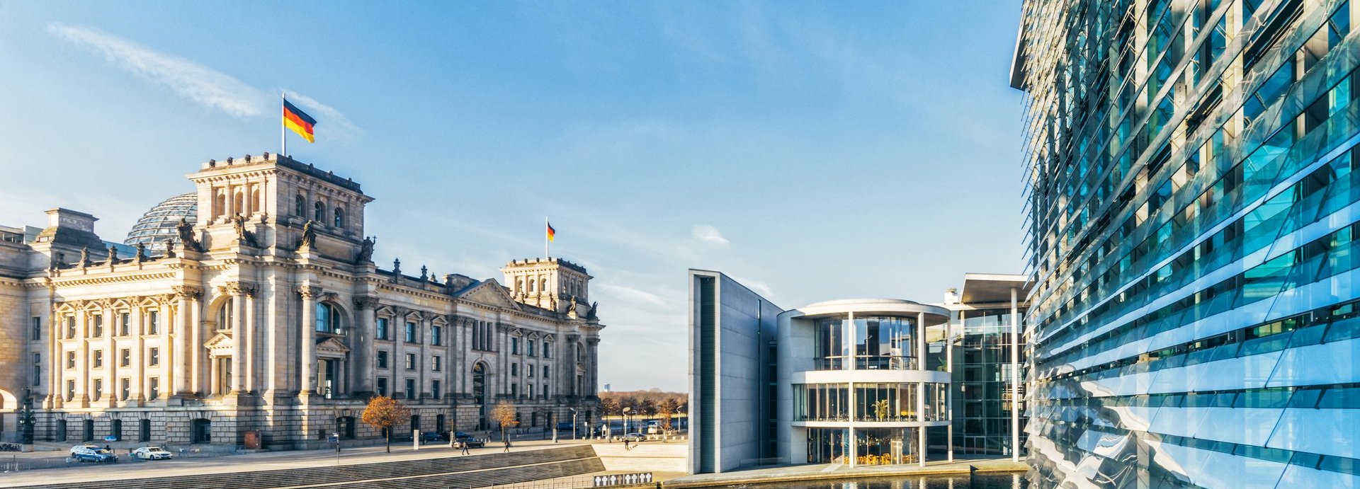 Fernansicht des Bundestags und weiterer Gebäude mit blauem Himmel und der Spree